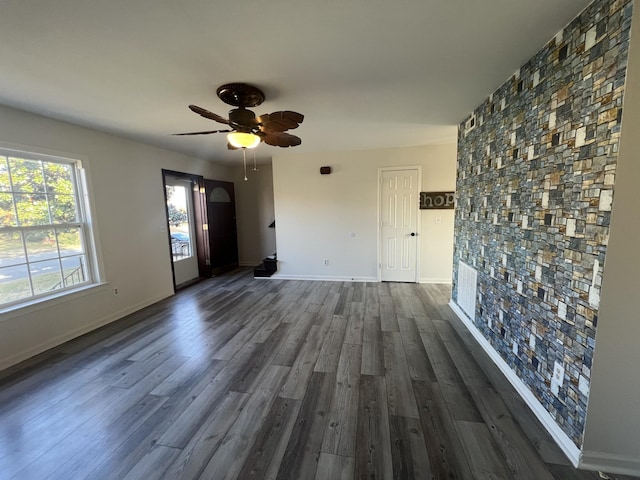 unfurnished living room with dark hardwood / wood-style floors and ceiling fan