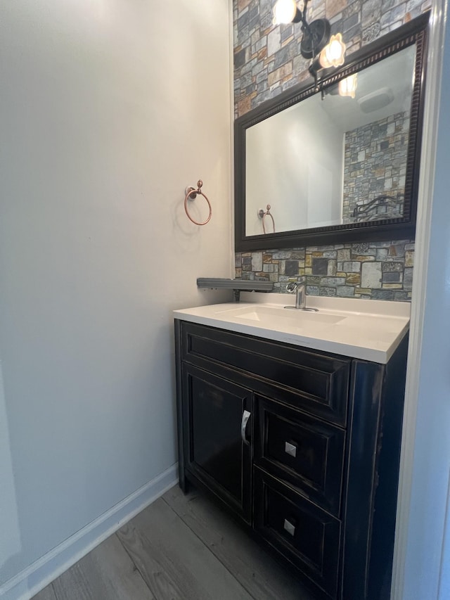 bathroom featuring hardwood / wood-style floors, vanity, and backsplash