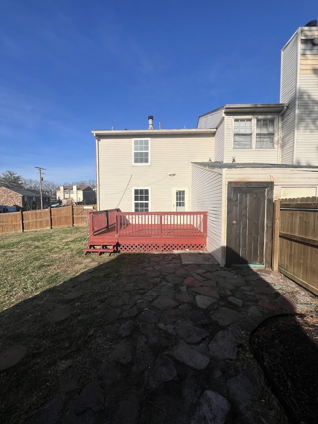 rear view of house featuring a lawn and a wooden deck