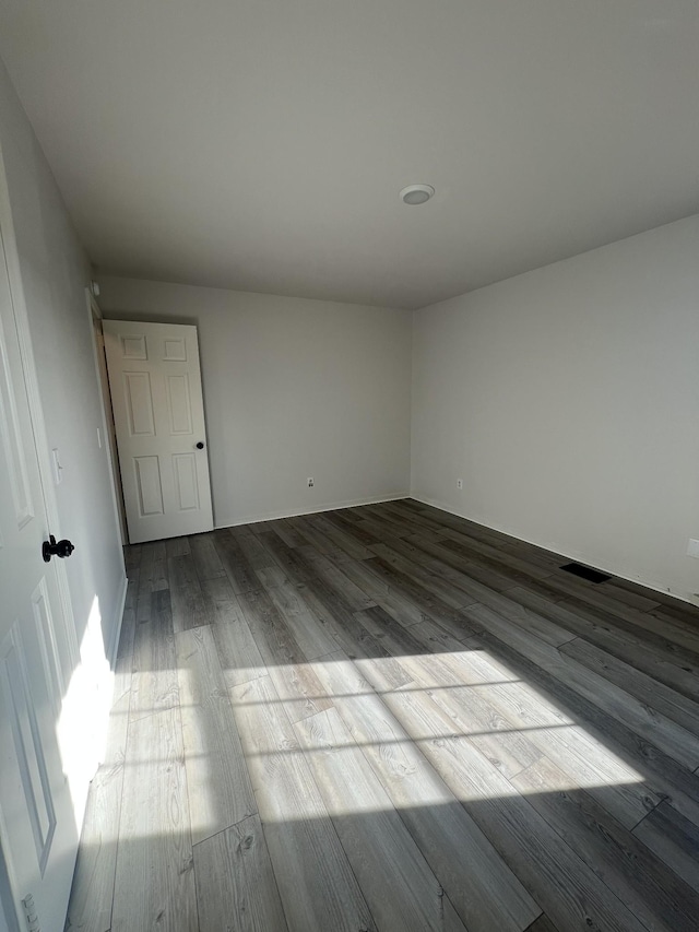 unfurnished room with wood-type flooring