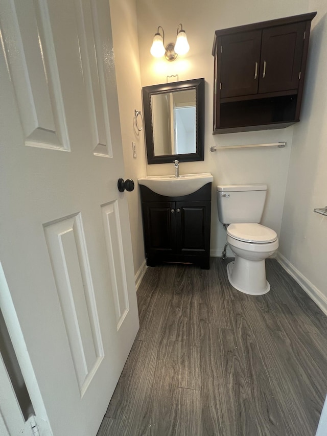 bathroom featuring vanity, wood-type flooring, and toilet