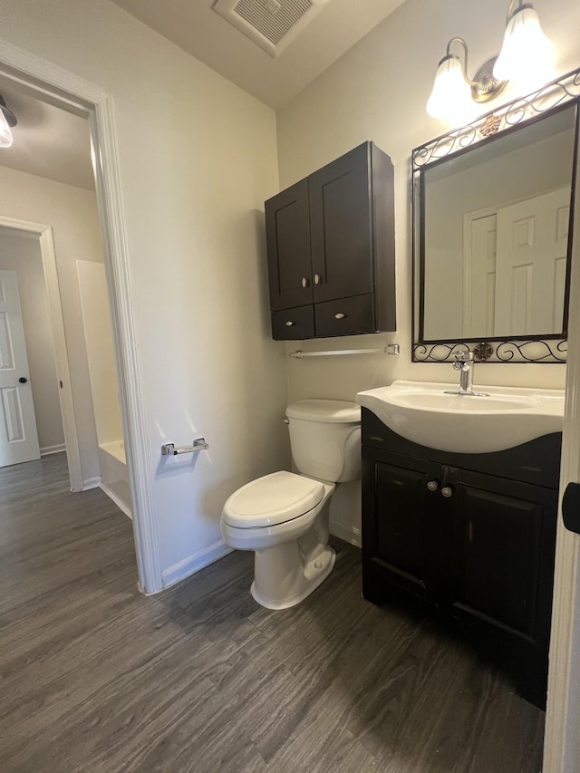 bathroom featuring toilet, vanity, and hardwood / wood-style flooring