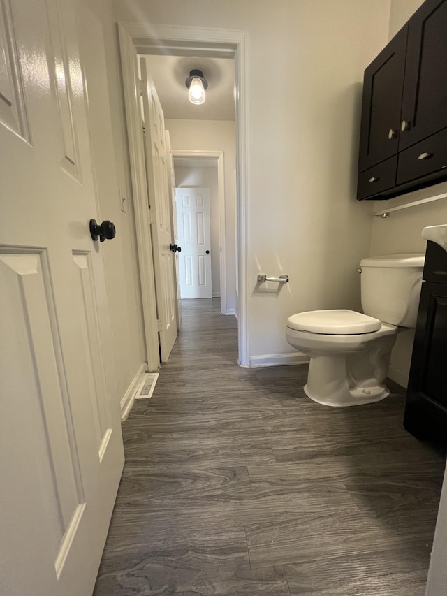 bathroom with wood-type flooring and toilet