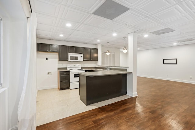 kitchen with pendant lighting, white appliances, sink, light hardwood / wood-style flooring, and kitchen peninsula