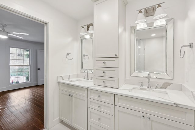 bathroom featuring wood-type flooring, vanity, ceiling fan, and ornamental molding