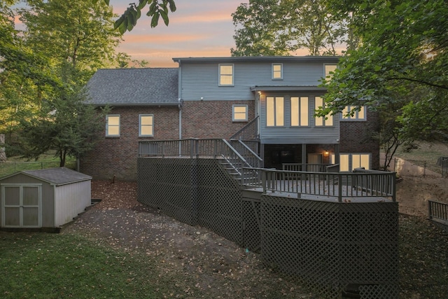 back house at dusk with a shed and a wooden deck