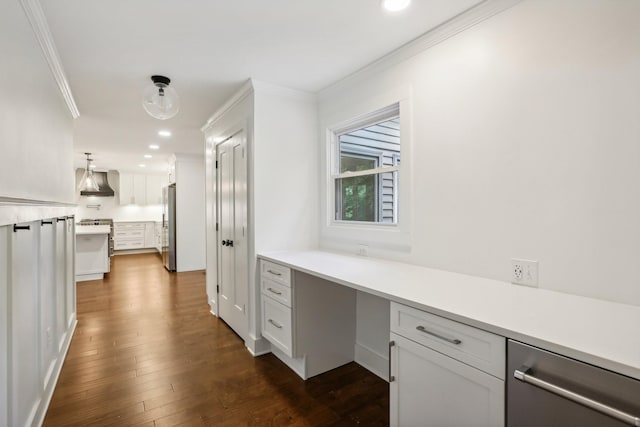 interior space with wall chimney exhaust hood, dark wood-type flooring, decorative light fixtures, white cabinets, and built in desk