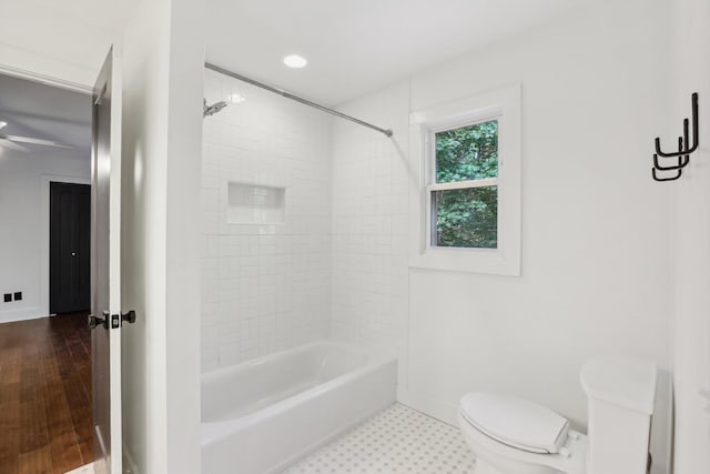 bathroom with shower / bath combination, toilet, and ceiling fan