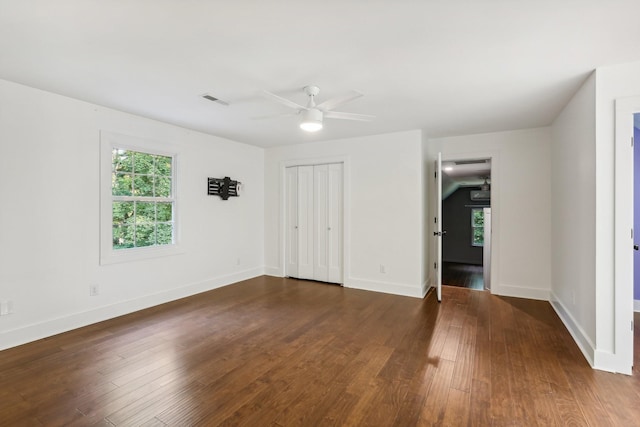 unfurnished bedroom featuring a closet, ceiling fan, and dark wood-type flooring