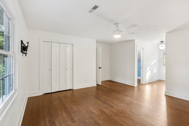 interior space with ceiling fan, dark wood-type flooring, and a closet