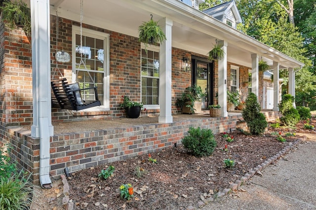 view of exterior entry featuring covered porch