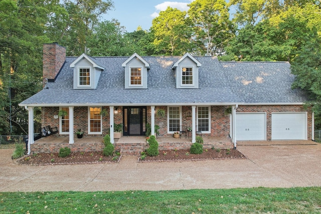 new england style home featuring a porch and a garage