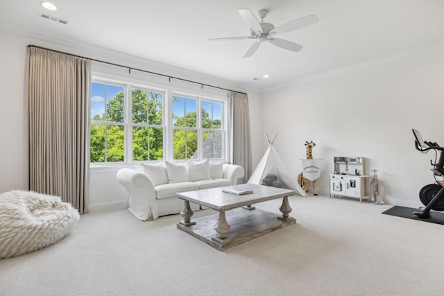 living room featuring carpet flooring, a wealth of natural light, crown molding, and ceiling fan