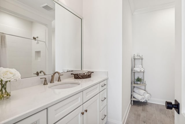 bathroom with crown molding, vanity, and walk in shower