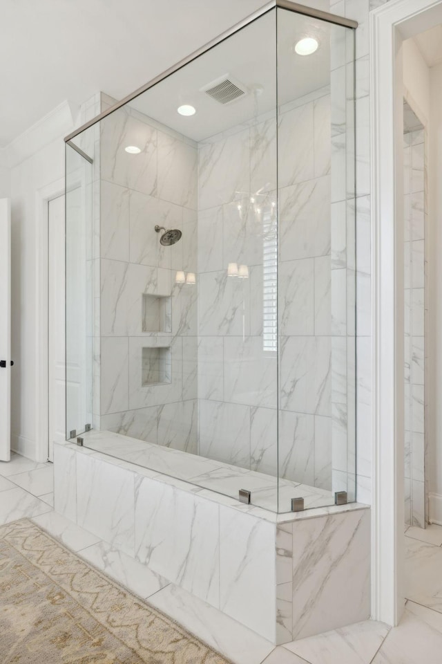 bathroom with a tile shower and crown molding