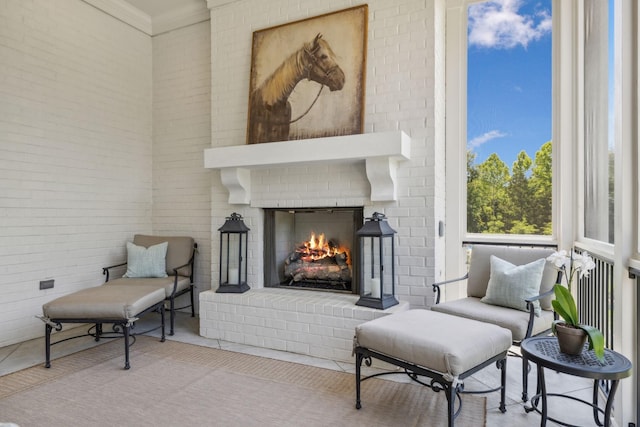 living area featuring an outdoor brick fireplace and ornamental molding