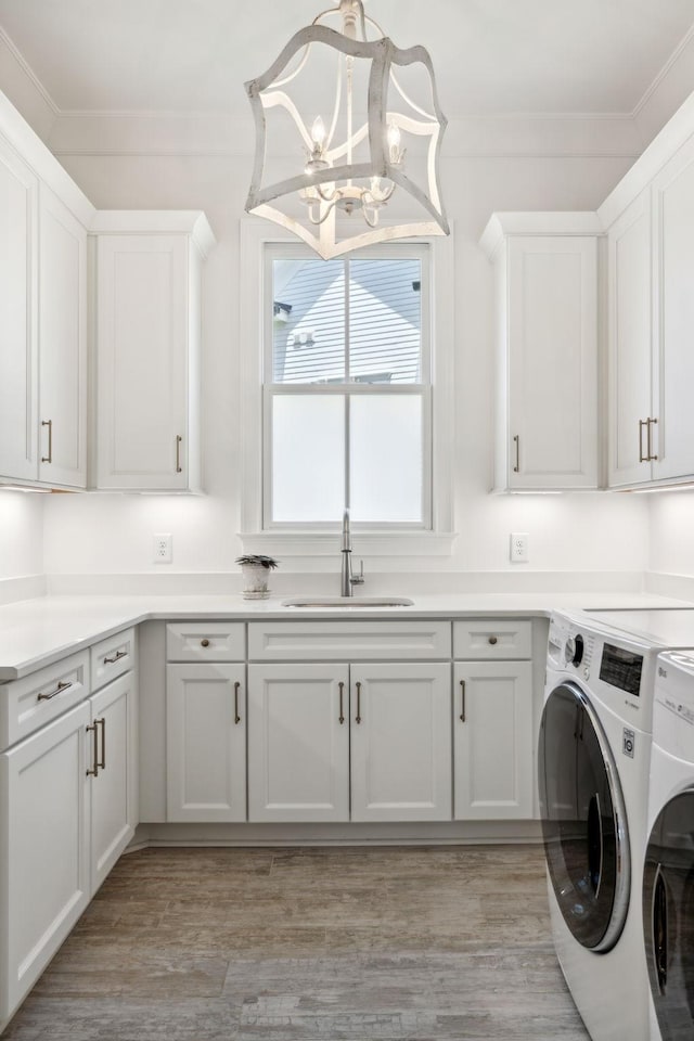 washroom with crown molding, cabinets, independent washer and dryer, and sink