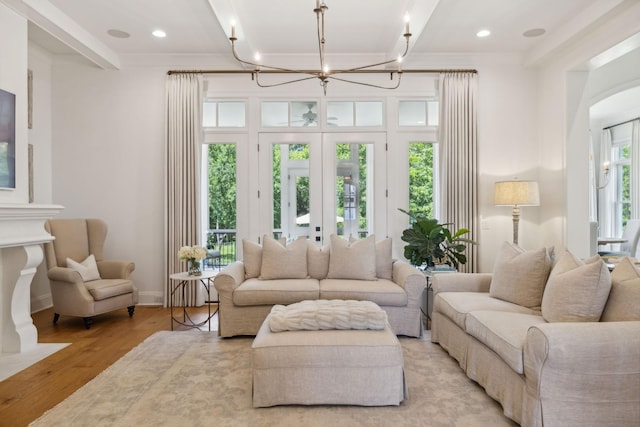 living room featuring beamed ceiling, french doors, light wood-type flooring, and plenty of natural light