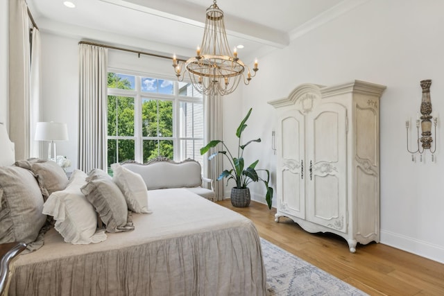 bedroom featuring beamed ceiling, light hardwood / wood-style floors, ornamental molding, and an inviting chandelier