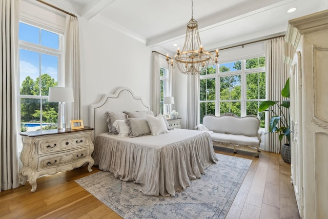 bedroom with beamed ceiling, multiple windows, and light hardwood / wood-style flooring