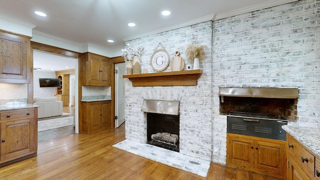 living room with crown molding, a fireplace, and light hardwood / wood-style floors