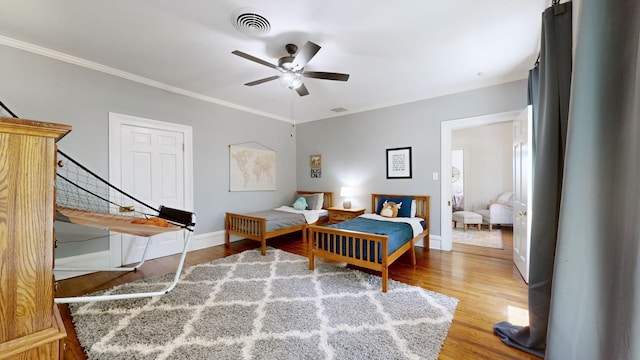 bedroom featuring hardwood / wood-style flooring, ceiling fan, and ornamental molding