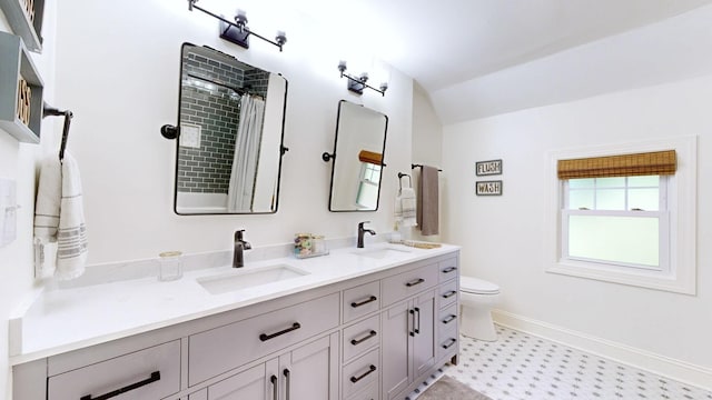 bathroom with vanity, toilet, and vaulted ceiling