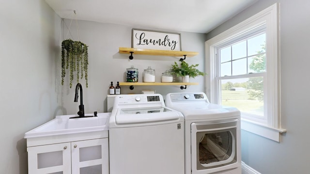 laundry room featuring cabinets, independent washer and dryer, and sink