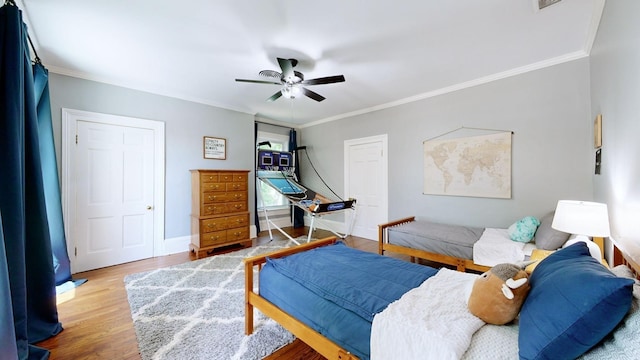 bedroom featuring ceiling fan, ornamental molding, and hardwood / wood-style flooring