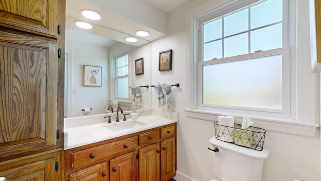 bathroom featuring vanity, toilet, and plenty of natural light