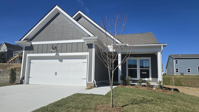 view of front of home featuring driveway, a shingled roof, an attached garage, a front lawn, and board and batten siding