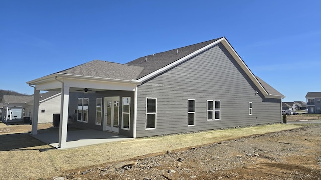 rear view of house featuring a patio area, ceiling fan, central AC unit, and a shingled roof