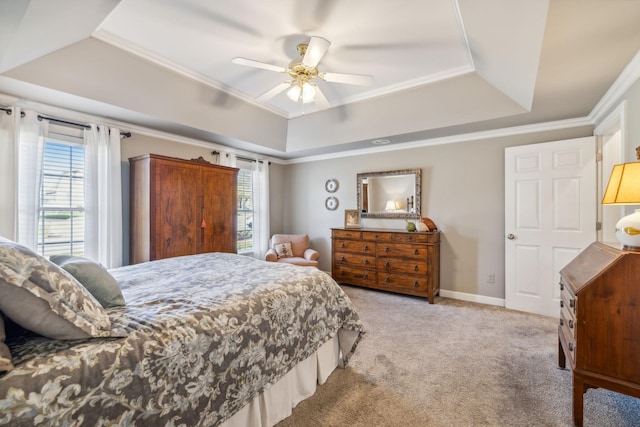 bedroom featuring ceiling fan, crown molding, light carpet, and a tray ceiling