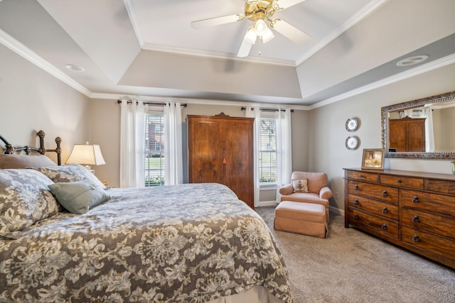 bedroom featuring a tray ceiling, multiple windows, ceiling fan, and light colored carpet