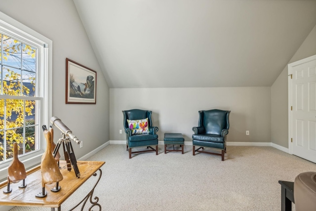 sitting room with a healthy amount of sunlight, light colored carpet, and vaulted ceiling