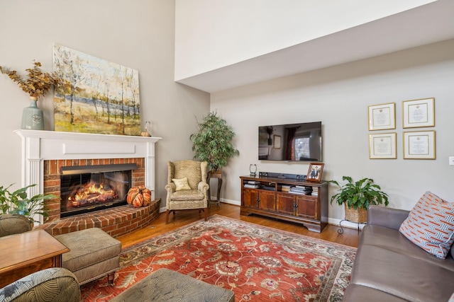 living room with hardwood / wood-style flooring and a brick fireplace