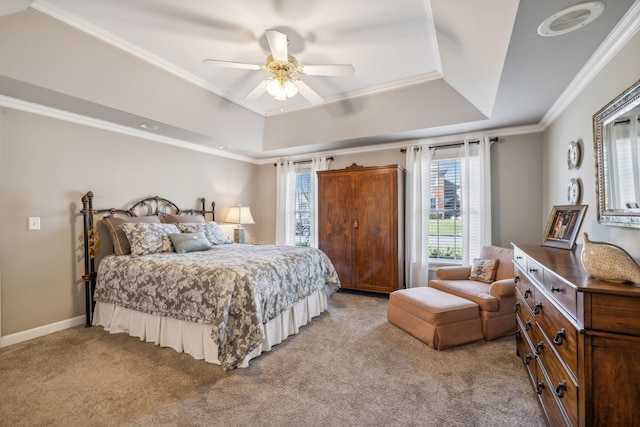 carpeted bedroom with a tray ceiling, ceiling fan, and ornamental molding