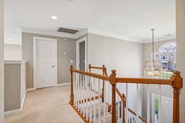 hall with a chandelier, light colored carpet, and crown molding