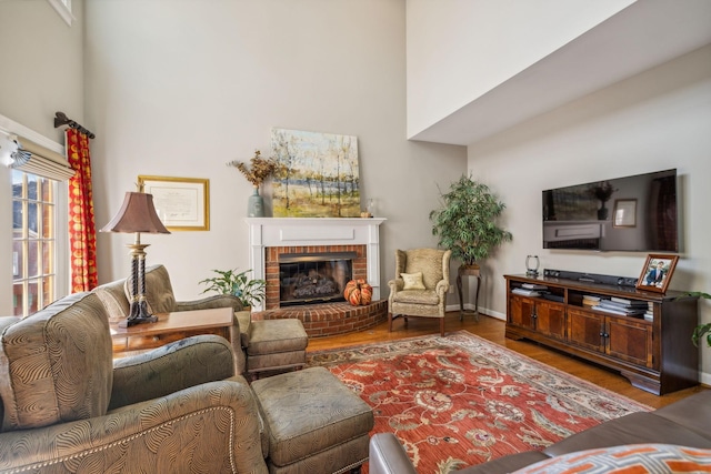 living room with wood-type flooring and a brick fireplace