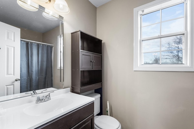 bathroom with vanity, toilet, plenty of natural light, and curtained shower