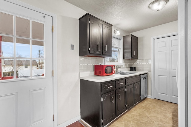 kitchen featuring dishwasher, sink, backsplash, a textured ceiling, and dark brown cabinets