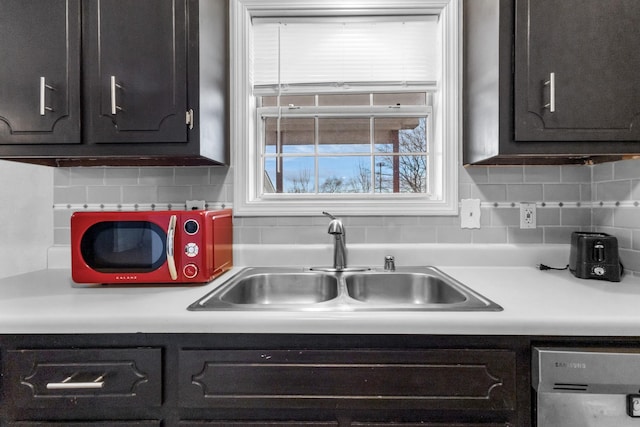 kitchen featuring tasteful backsplash, dark brown cabinetry, dishwasher, and sink