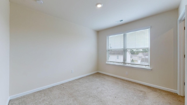 spare room featuring light colored carpet