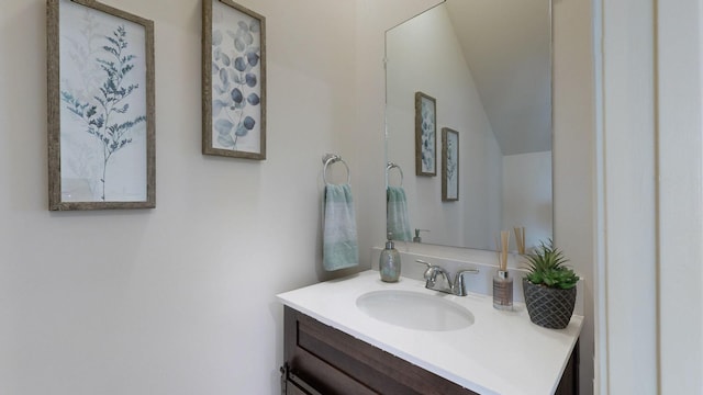 bathroom with vanity and lofted ceiling