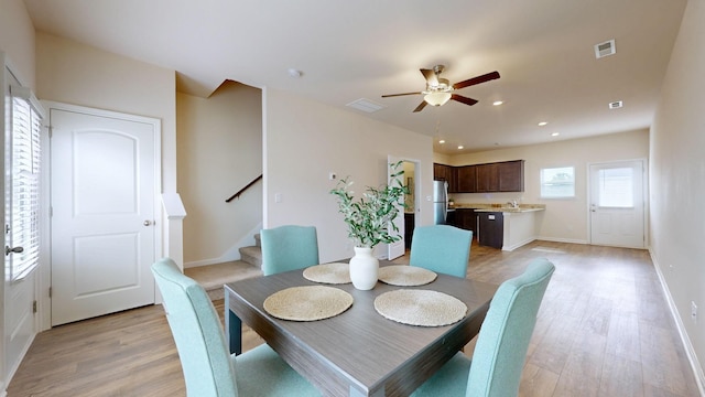 dining room featuring ceiling fan, light wood-type flooring, and sink