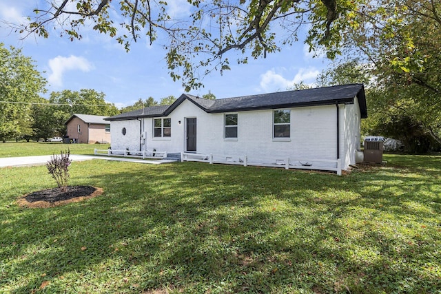 ranch-style home featuring cooling unit and a front lawn