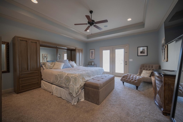 carpeted bedroom featuring access to exterior, a tray ceiling, ceiling fan, and crown molding