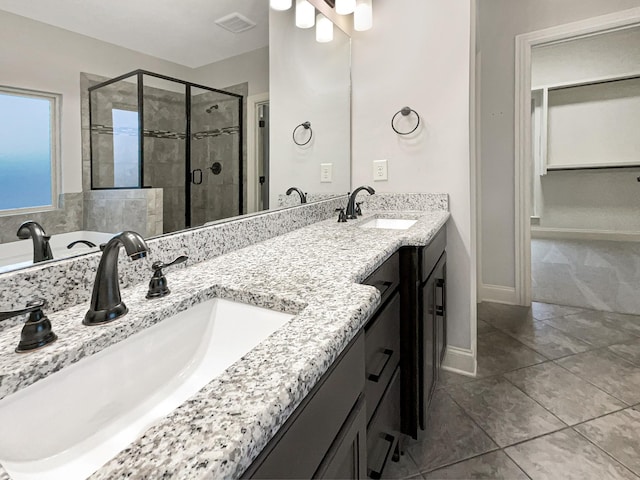 bathroom with tile patterned floors, vanity, and walk in shower