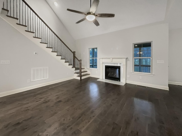 unfurnished living room featuring a fireplace, dark hardwood / wood-style floors, and ceiling fan