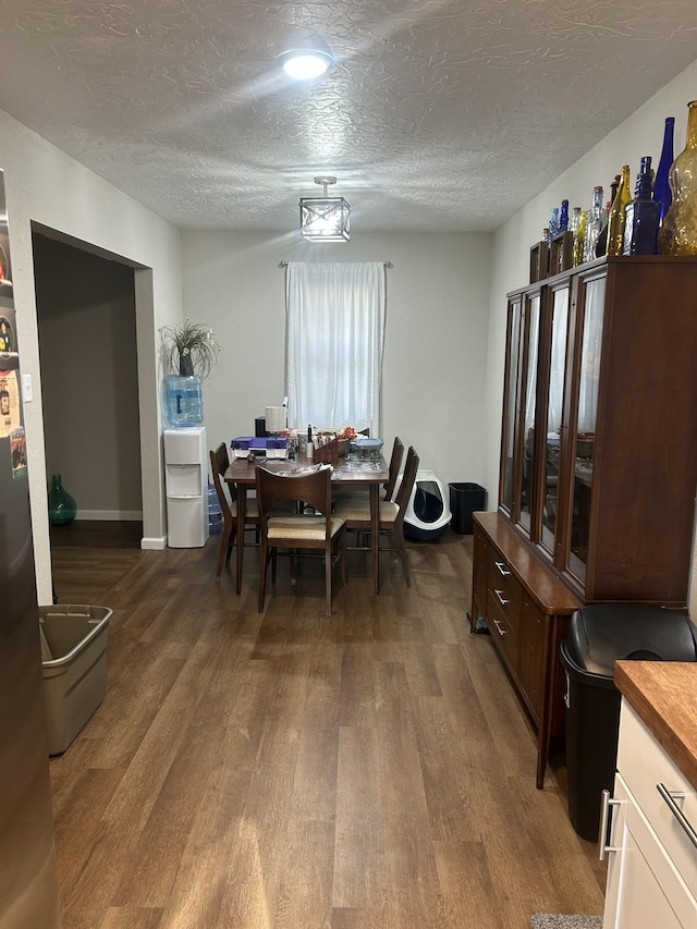 dining space featuring dark hardwood / wood-style floors and a textured ceiling